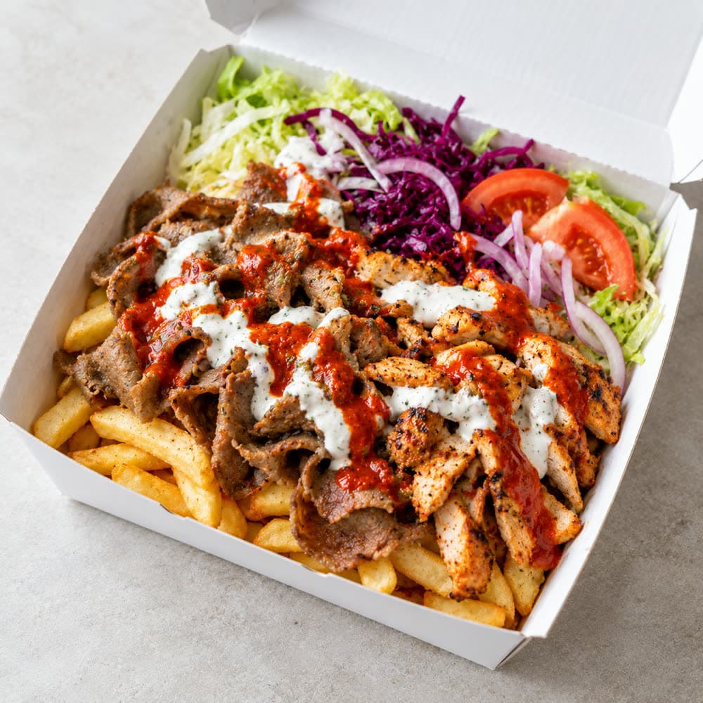 A kebab box: doner and chicken over chips with salad and sauces